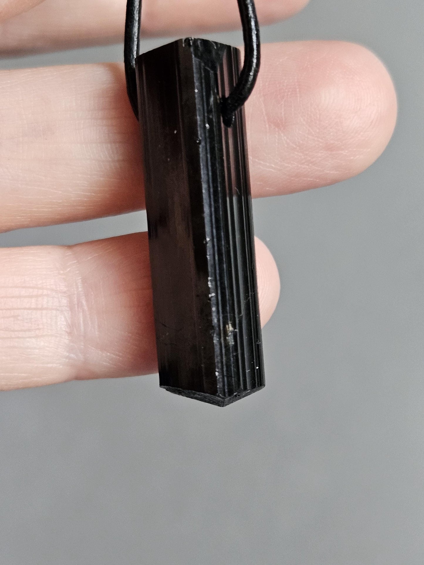 Magischer Schutzstein schwarzer Turmalin Schörl, roh belassen, Oberkante geschliffen, 37 x 11 x 10 mm, gebohrt, an Lederband