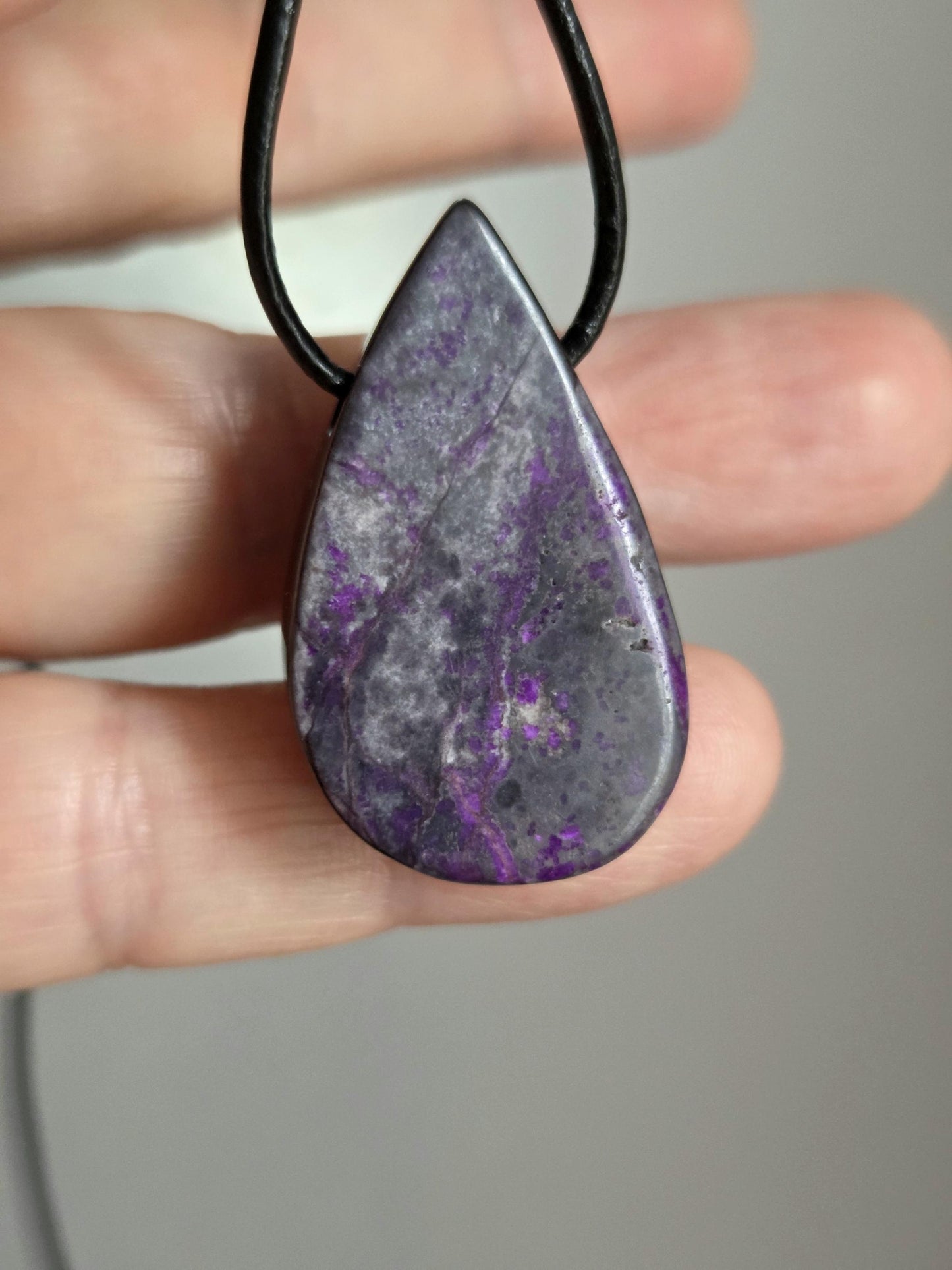 Hübscher Sugilith Anhänger tropfenförmig, 34 x 19 x 6 mm, gebohrt, an verstellbarem Lederband