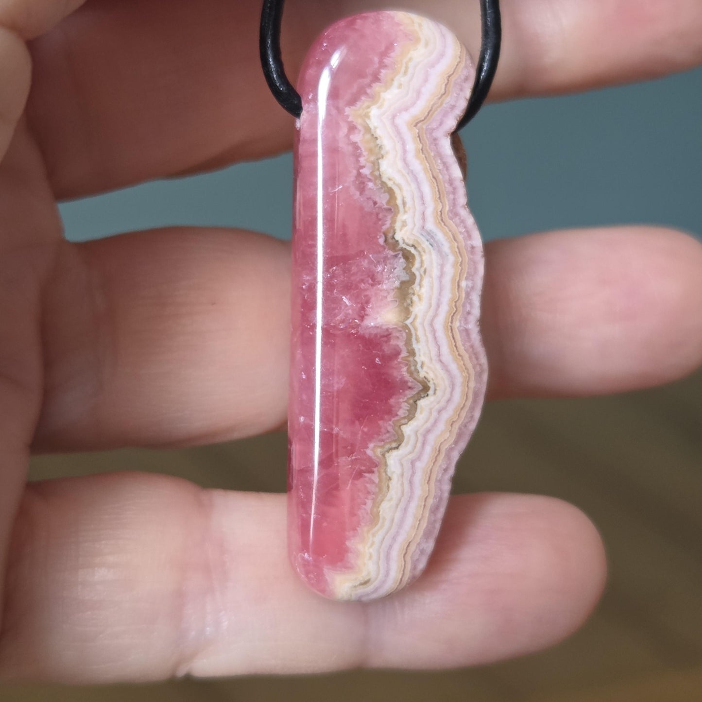 Wilder Rhodochrosit Anhänger mit einzigartiger Bänderung, 48 x 18 x 9 mm, an Lederband, high quality polish, heart chakra, self love