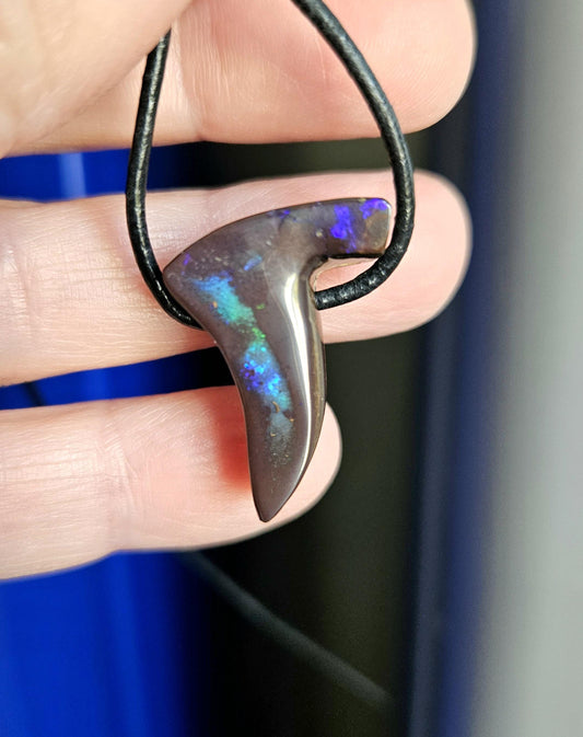dieser wunderschöne australische Boulder Opal hat die Form eines Damenschuhs , er hat blau türkis lila Opalschichtem mit flashfire und pinfire und hängt an einem schwarzen Lederband