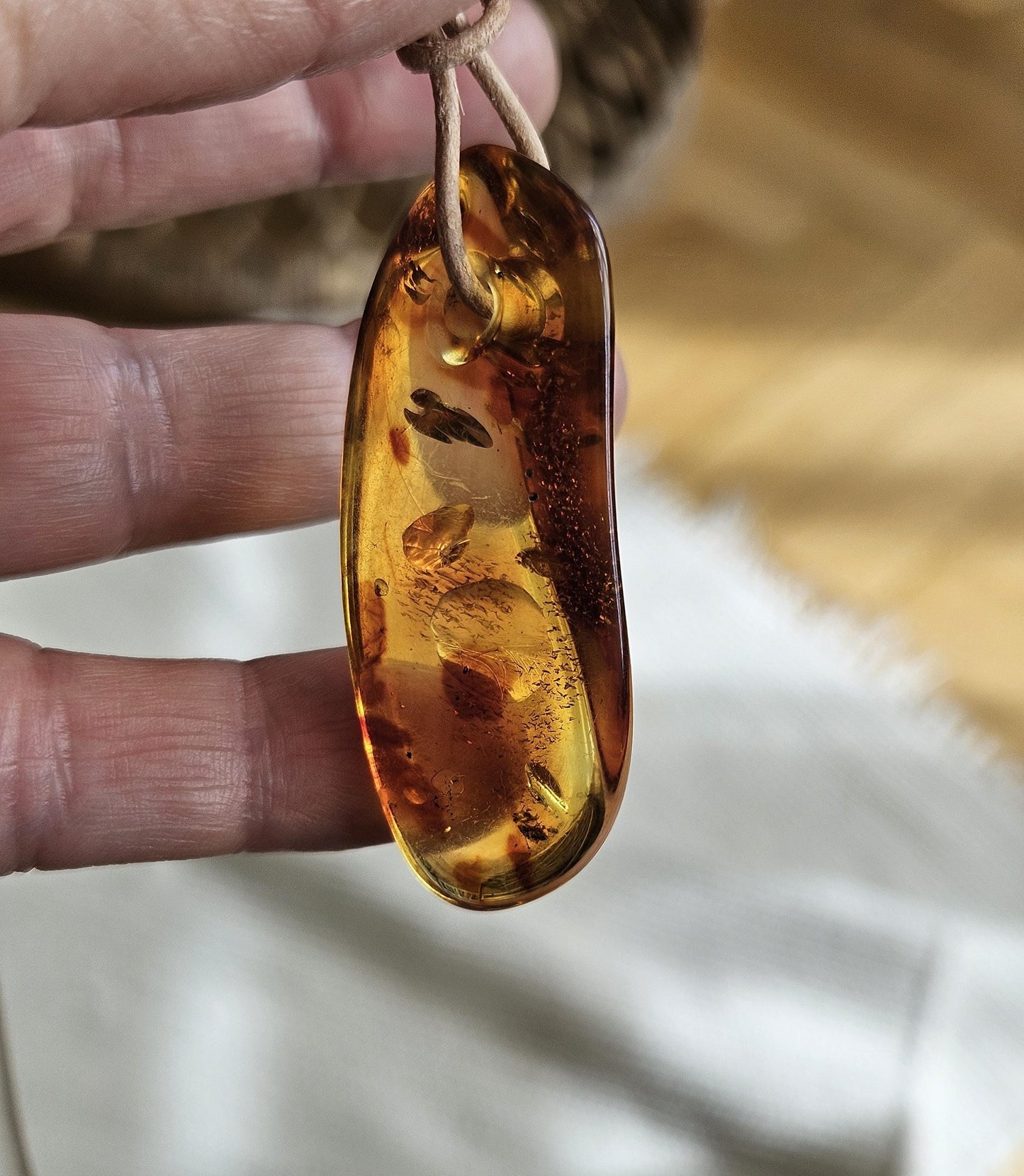 Feiner Bernstein Anhänger, mit Einschlüssen von Blüten Blätterskelett Bernstein Amulett, gebohrt 54 x 24 x 14 mm, an verstellbarem Lederband