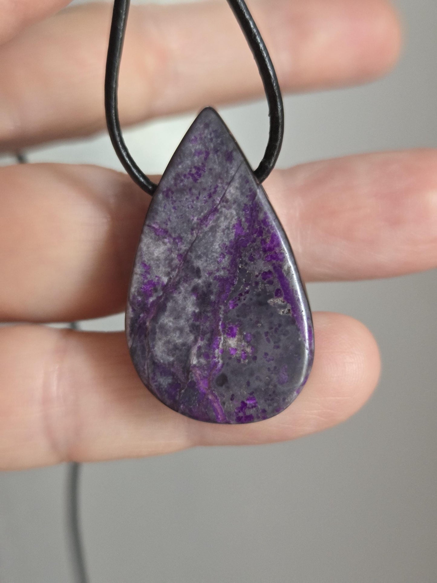 Hübscher Sugilith Anhänger tropfenförmig, 34 x 19 x 6 mm, gebohrt, an verstellbarem Lederband