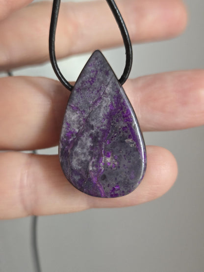 Hübscher Sugilith Anhänger tropfenförmig, 34 x 19 x 6 mm, gebohrt, an verstellbarem Lederband