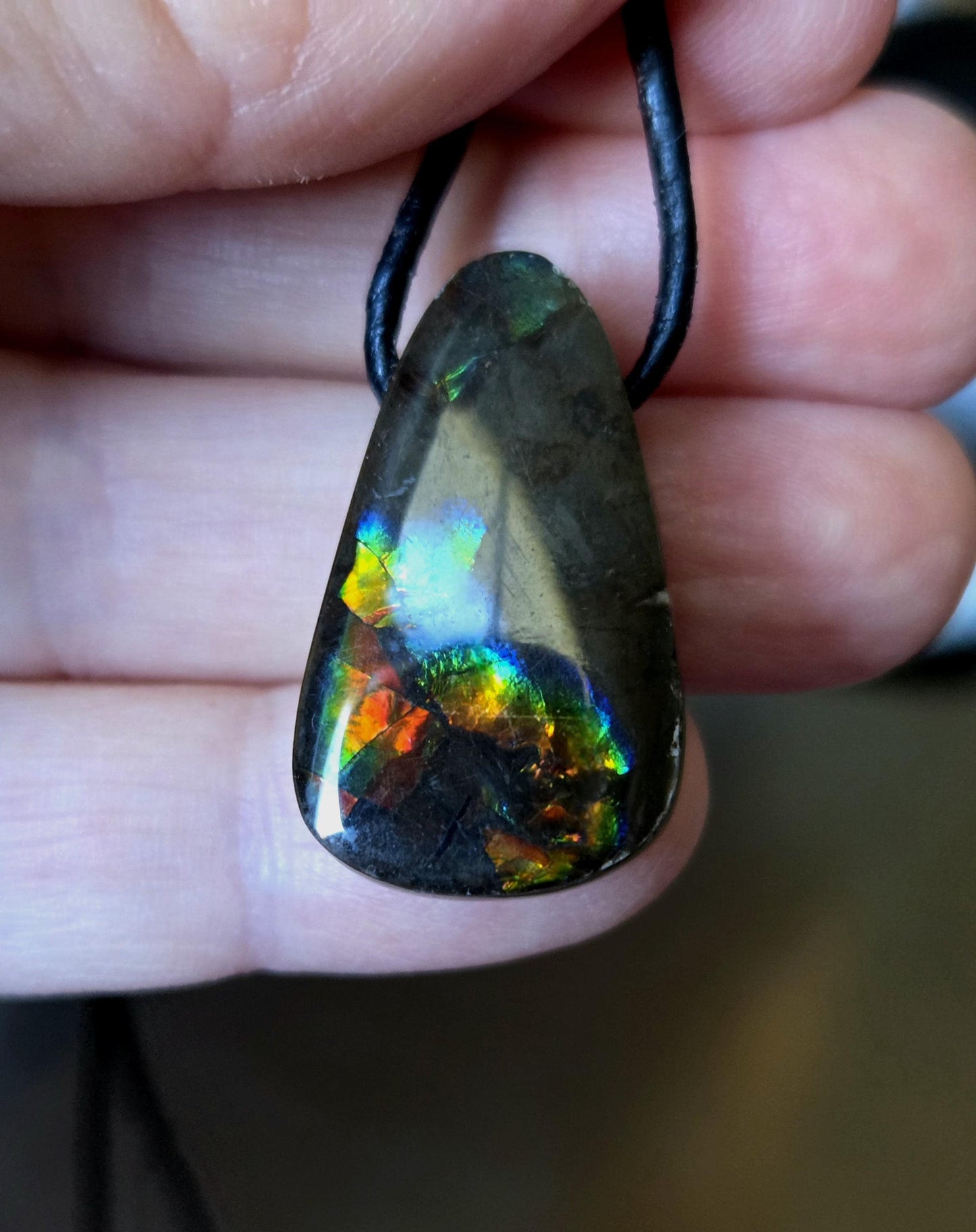 Geheimnisvoller Ammolit Opal rot blau grün gelb, aus Alberta Kanada, Anhänger, 28 x 18 x 9 mm, gebohrt, an verstellbarem Lederband