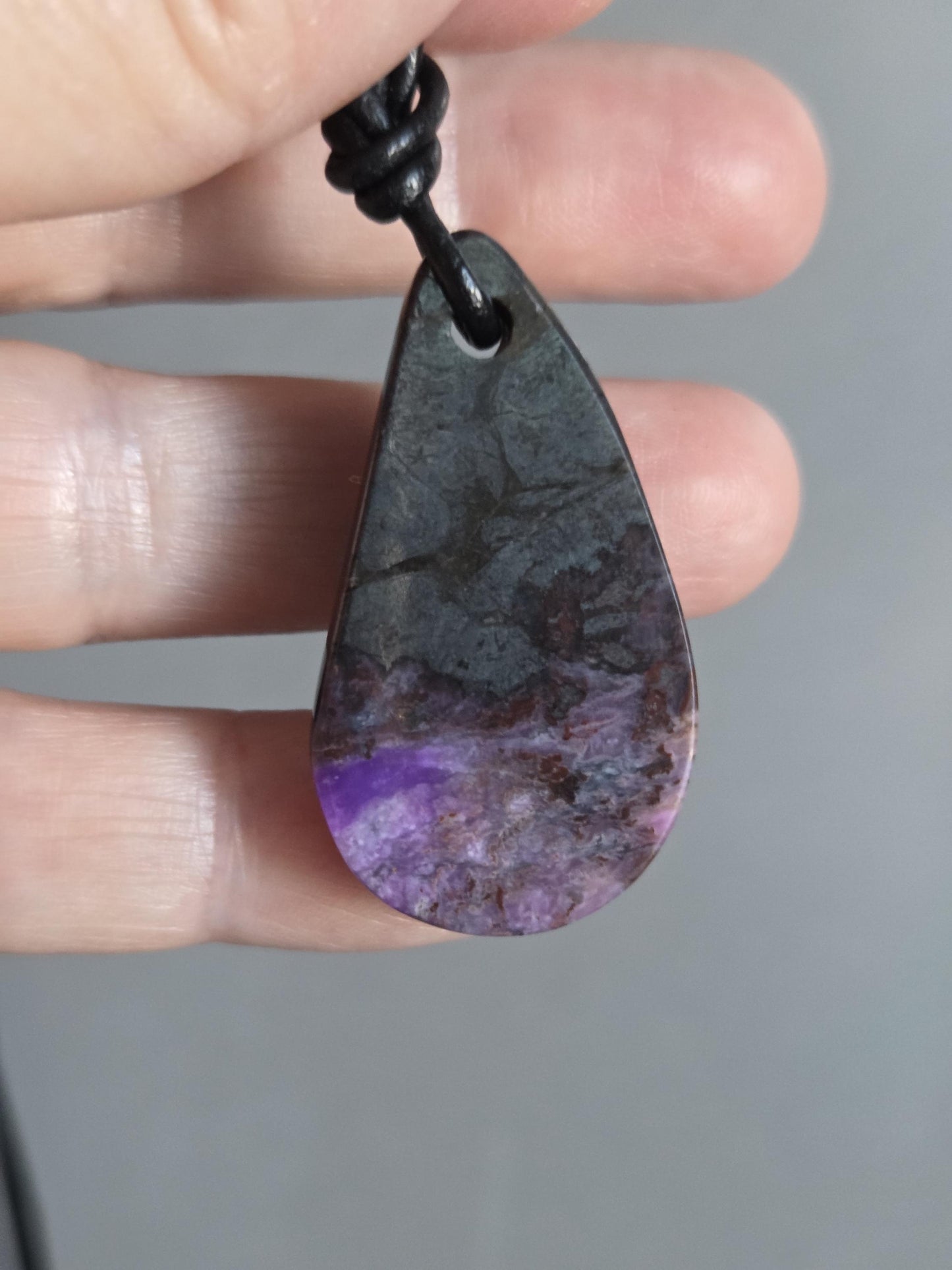 Magischer Sugilith Anhänger tropfenförmig, 39 x 23 x 7 mm, gebohrt, an verstellbarem Lederband