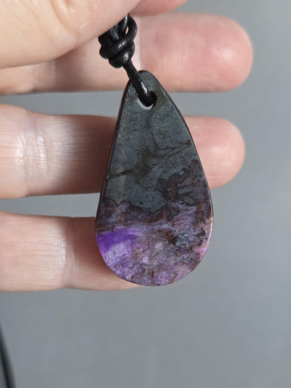 Magischer Sugilith Anhänger tropfenförmig, 39 x 23 x 7 mm, gebohrt, an verstellbarem Lederband