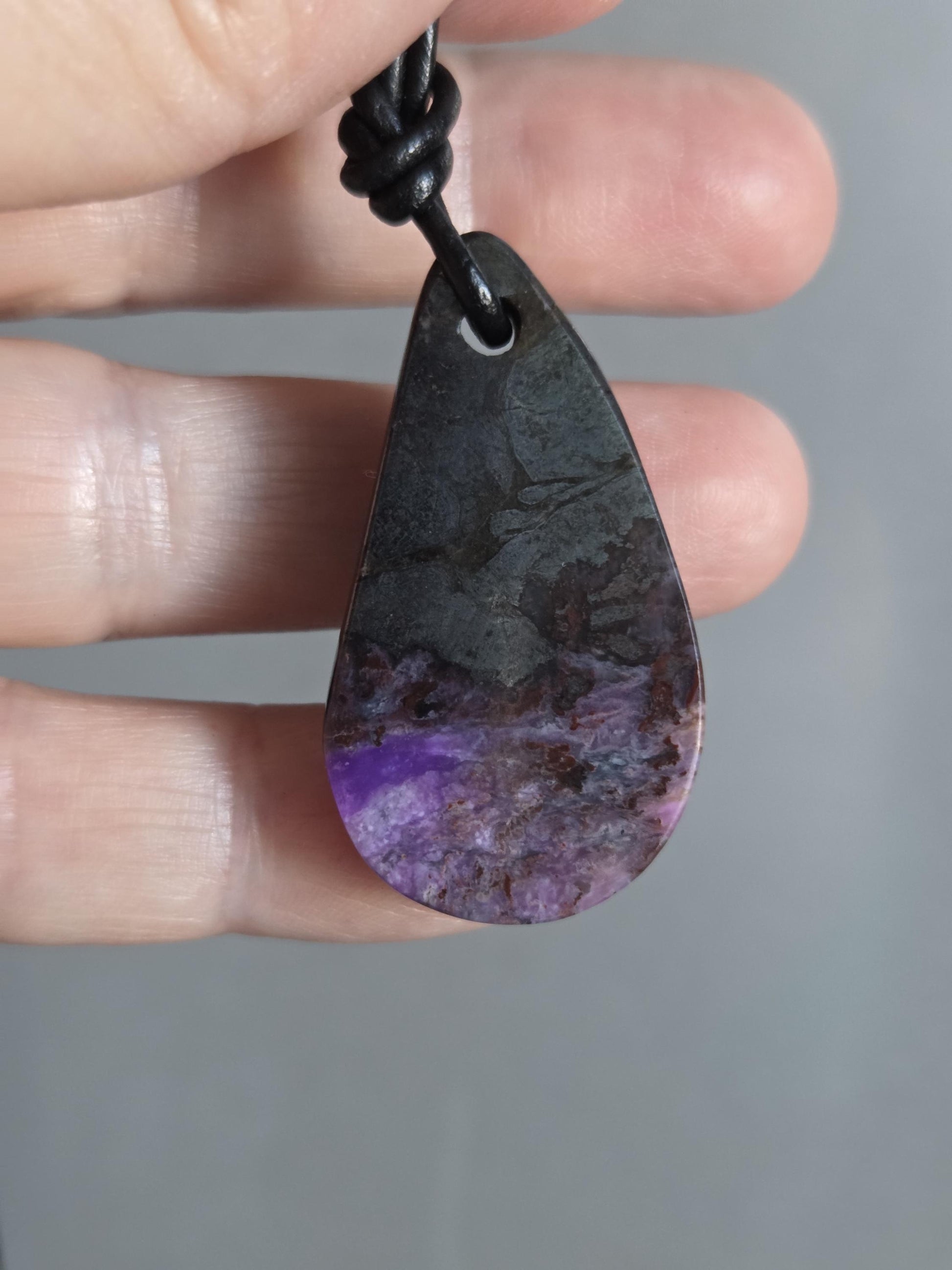 Magischer Sugilith Anhänger tropfenförmig, 39 x 23 x 7 mm, gebohrt, an verstellbarem Lederband