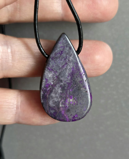 Hübscher Sugilith Anhänger tropfenförmig, 34 x 19 x 6 mm, gebohrt, an verstellbarem Lederband