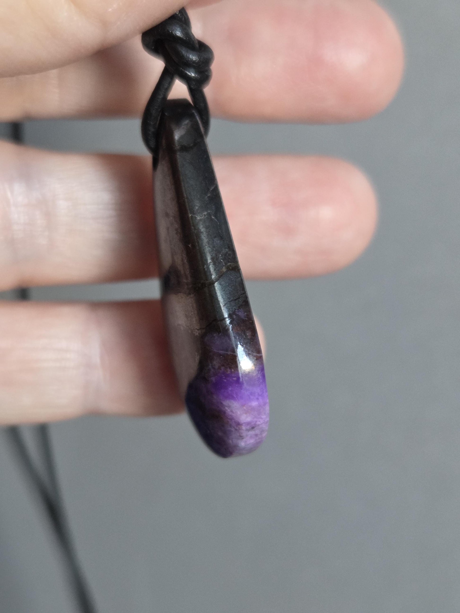 Magischer Sugilith Anhänger tropfenförmig, 39 x 23 x 7 mm, gebohrt, an verstellbarem Lederband