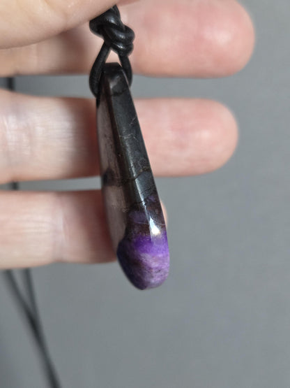 Magischer Sugilith Anhänger tropfenförmig, 39 x 23 x 7 mm, gebohrt, an verstellbarem Lederband