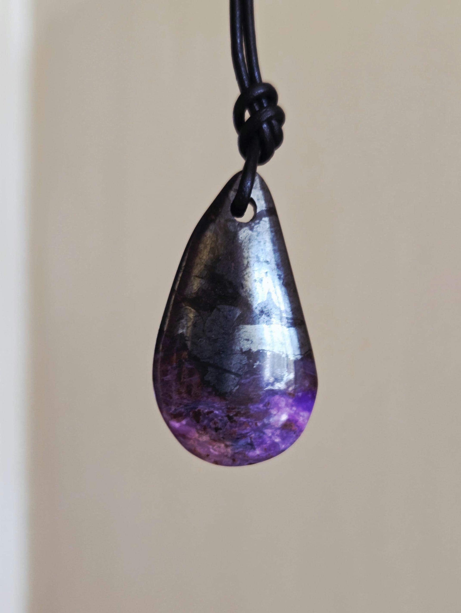 Magischer Sugilith Anhänger tropfenförmig, 39 x 23 x 7 mm, gebohrt, an verstellbarem Lederband