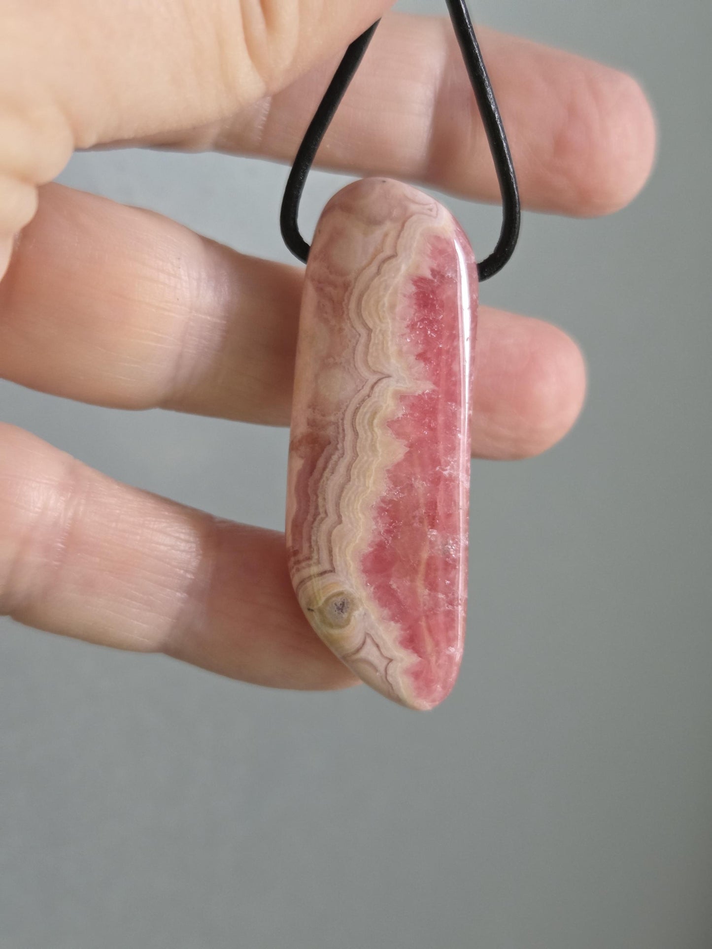 Wunderschöner Rhodochrosit Anhänger mit einzigartiger Bänderung, 49 x 18 x 8 mm, an Lederband, high quality polish, heart chakra, self love