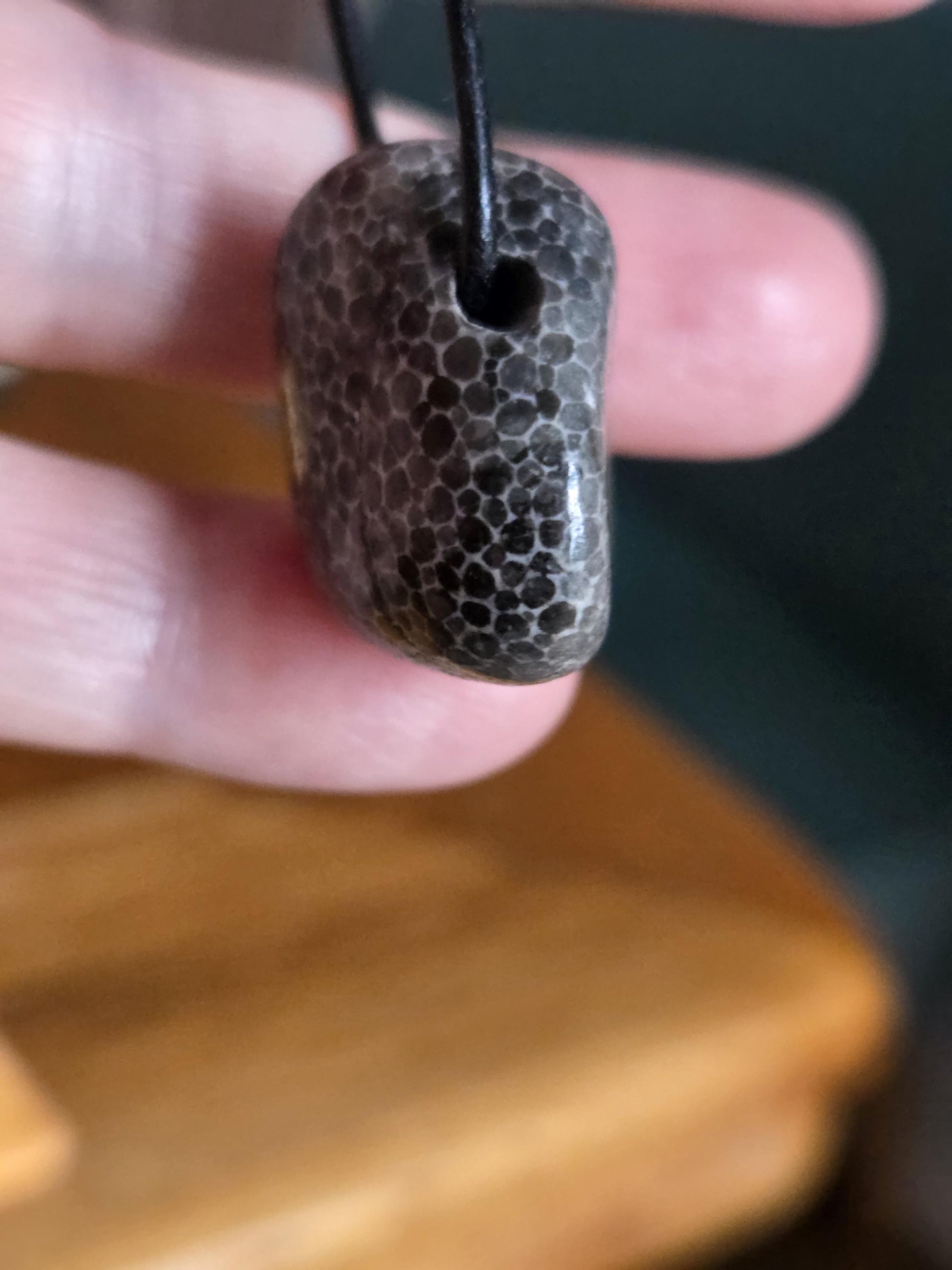 Versteinerte Koralle schwarz, Anhänger, 25 x 23 x 15 mm, gebohrt, an verstellbarem Lederband, Schlangenhaut Muster