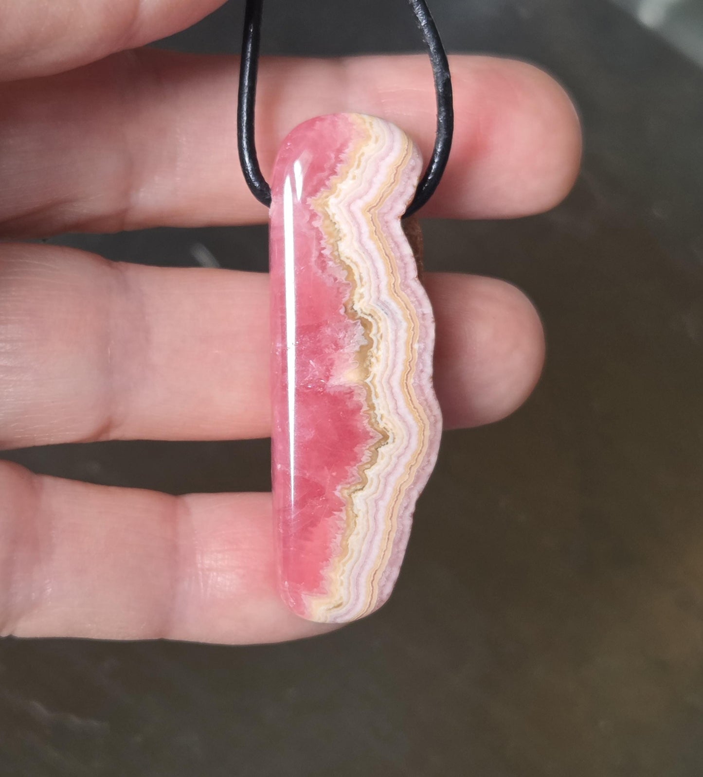 Wilder Rhodochrosit Anhänger mit einzigartiger Bänderung, 48 x 18 x 9 mm, an Lederband, high quality polish, heart chakra, self love
