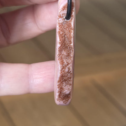 Wilder Rhodochrosit Anhänger mit einzigartiger Bänderung, 48 x 18 x 9 mm, an Lederband, high quality polish, heart chakra, self love
