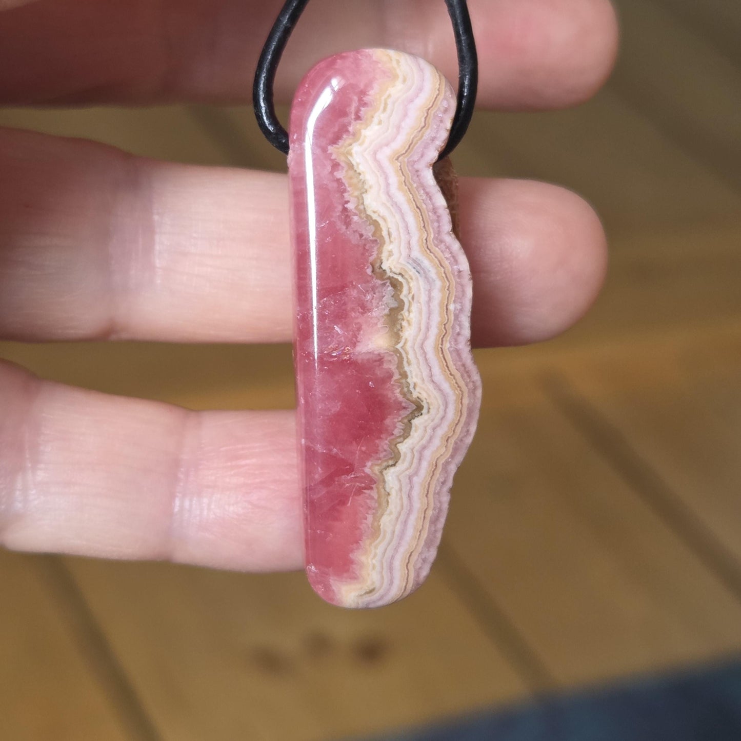 Wilder Rhodochrosit Anhänger mit einzigartiger Bänderung, 48 x 18 x 9 mm, an Lederband, high quality polish, heart chakra, self love