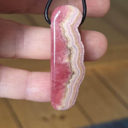 Wilder Rhodochrosit Anhänger mit einzigartiger Bänderung, 48 x 18 x 9 mm, an Lederband, high quality polish, heart chakra, self love