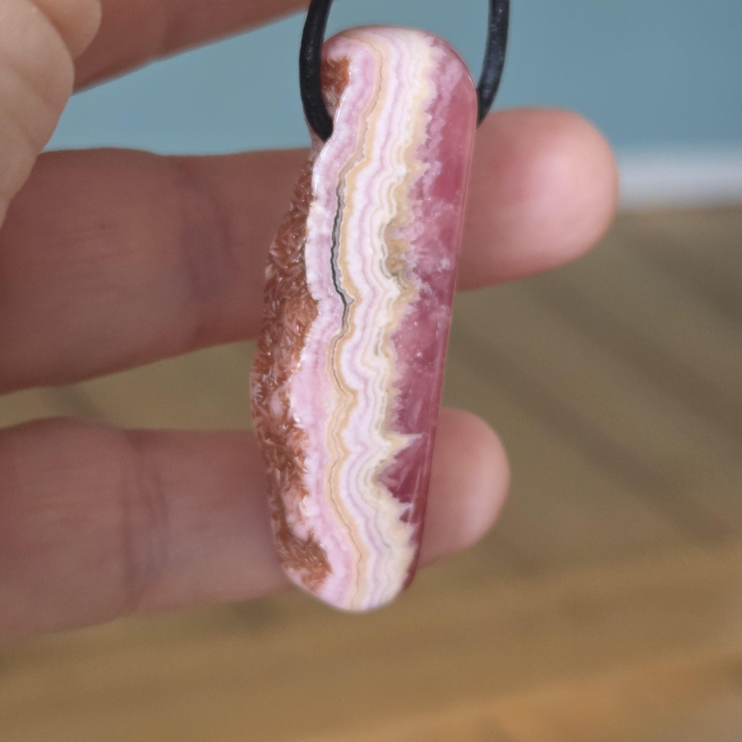 Wilder Rhodochrosit Anhänger mit einzigartiger Bänderung, 48 x 18 x 9 mm, an Lederband, high quality polish, heart chakra, self love