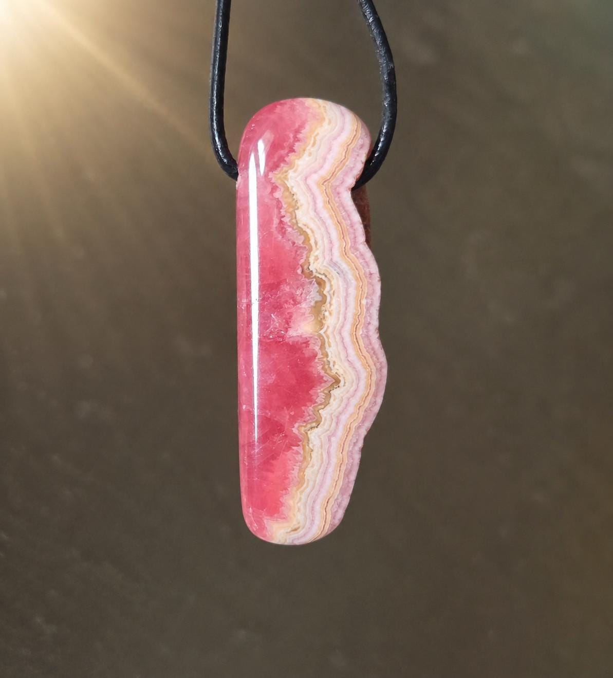 Wilder Rhodochrosit Anhänger mit einzigartiger Bänderung, 48 x 18 x 9 mm, an Lederband, high quality polish, heart chakra, self love