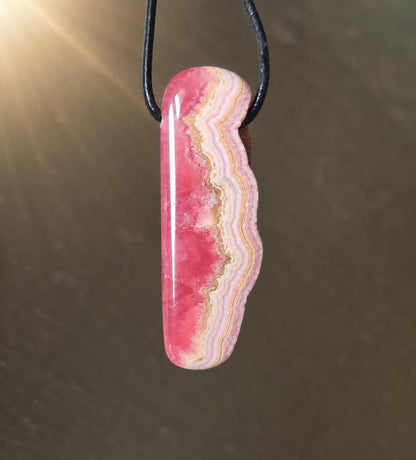 Wilder Rhodochrosit Anhänger mit einzigartiger Bänderung, 48 x 18 x 9 mm, an Lederband, high quality polish, heart chakra, self love