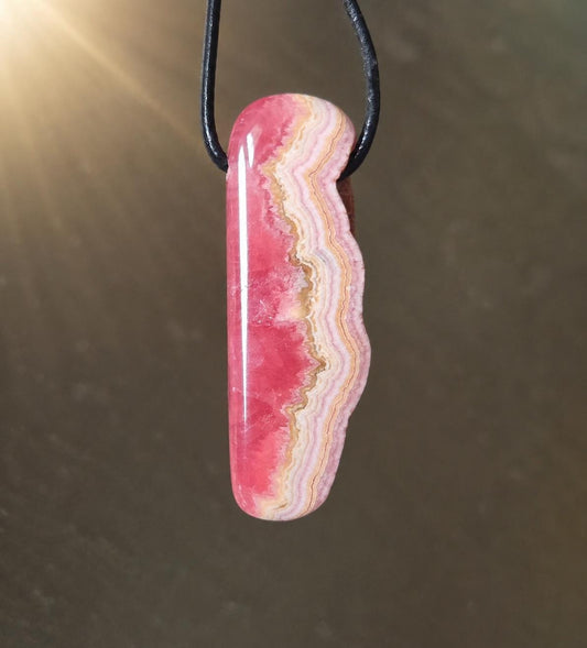 Wilder Rhodochrosit Anhänger mit einzigartiger Bänderung, 48 x 18 x 9 mm, an Lederband, high quality polish, heart chakra, self love