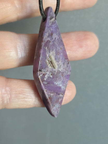 Sugilith Anhänger, 53 x 20 x 9 mm, gebohrt, an verstellbarem Lederband, beidseitig tragbar