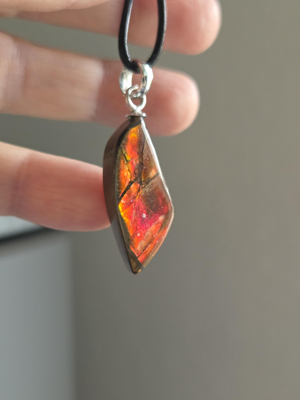 Ammolit Opal, Anhänger, 43 x 15 x 8 mm, an 925er Silber Öse, an verstellbarem Lederband