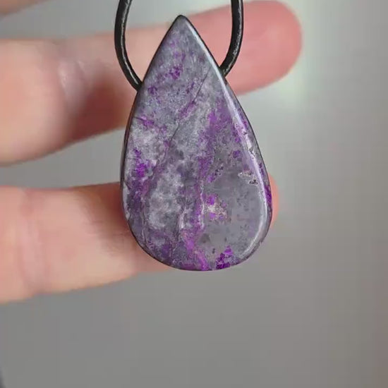 Hübscher Sugilith Anhänger tropfenförmig, 34 x 19 x 6 mm, gebohrt, an verstellbarem Lederband